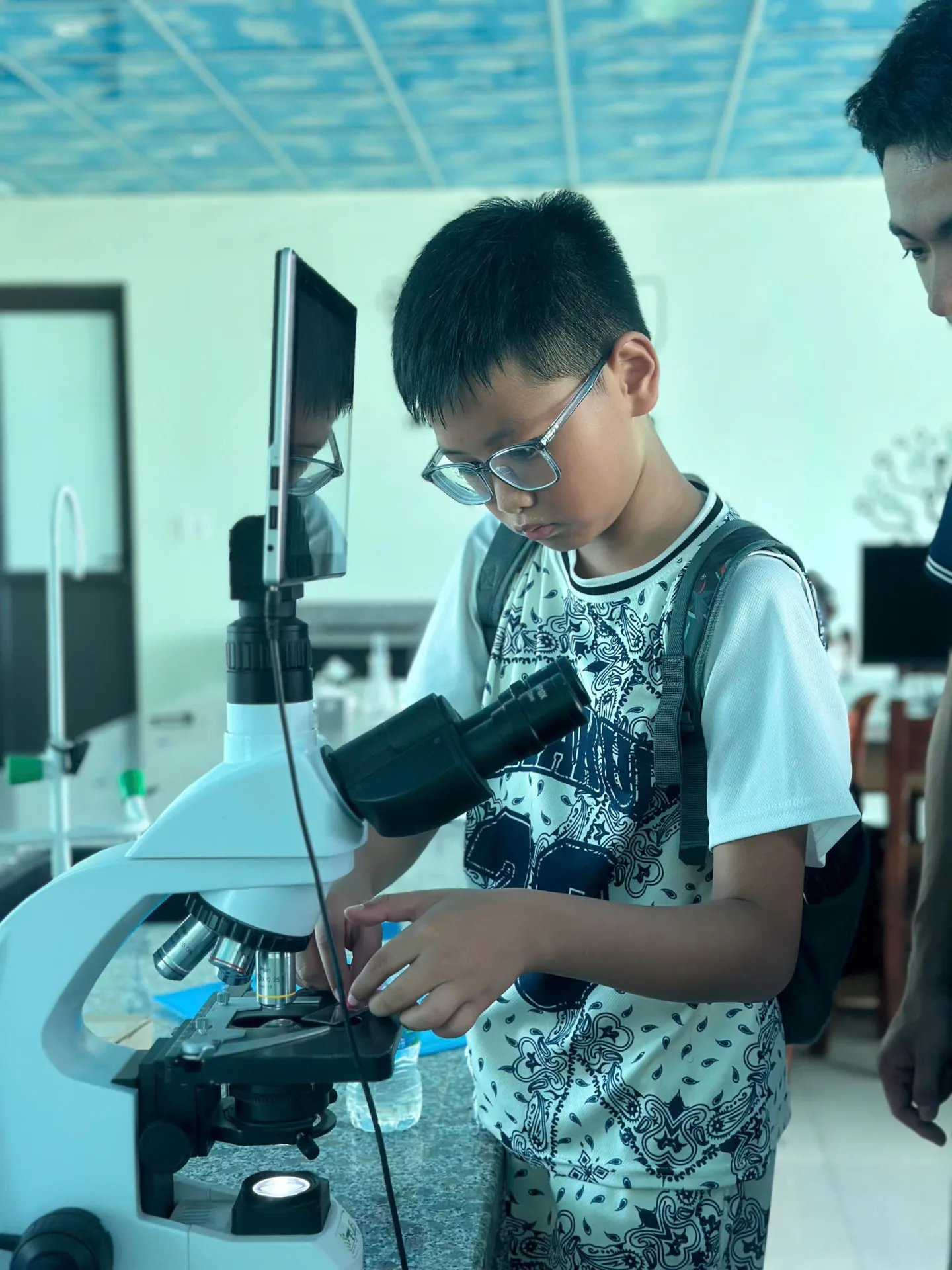 Trẻ quan sát qua kính hiển vi